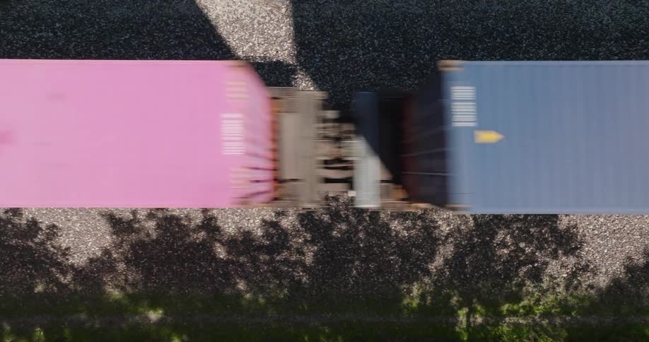 Close up traverse over fast moving and colorful shipping containers