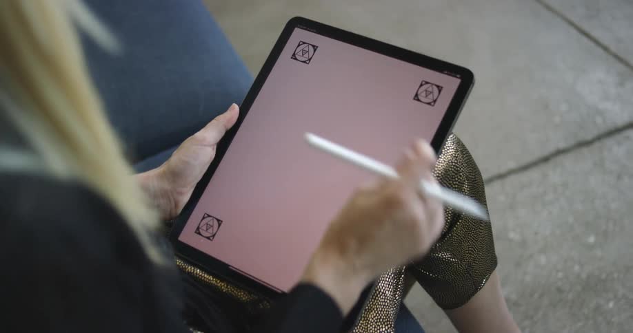 A woman looks at a tablet and then starts swiping on it