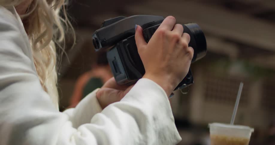 A woman takes pictures with her camera in the park