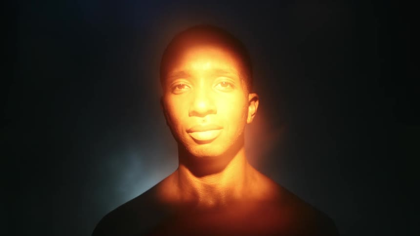 Light shifting on a mans face from shadow to glare