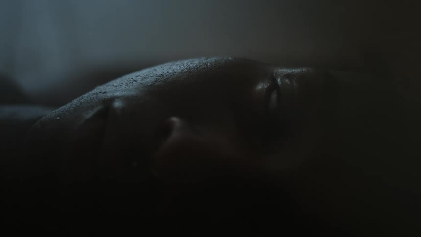 A man lies on his back with his head to the side
