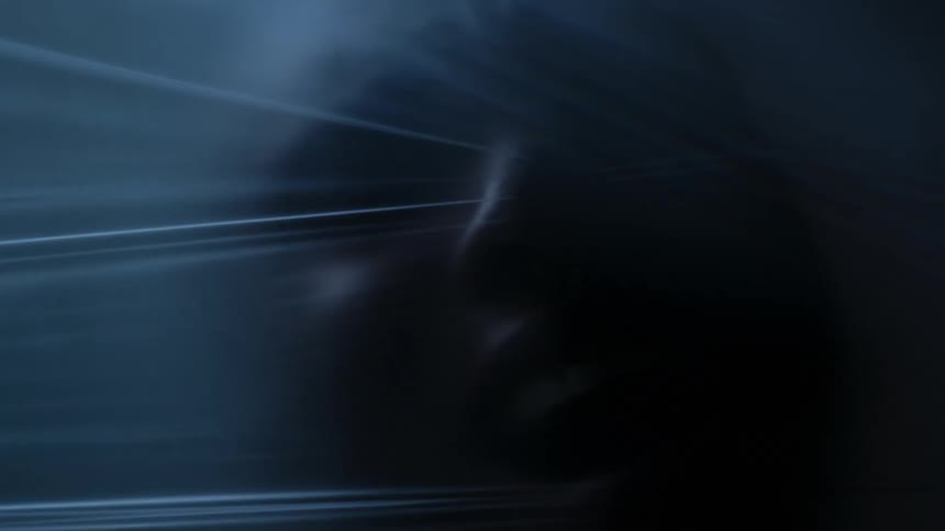 Close up of the face of a man behind a tight translucent plastic film