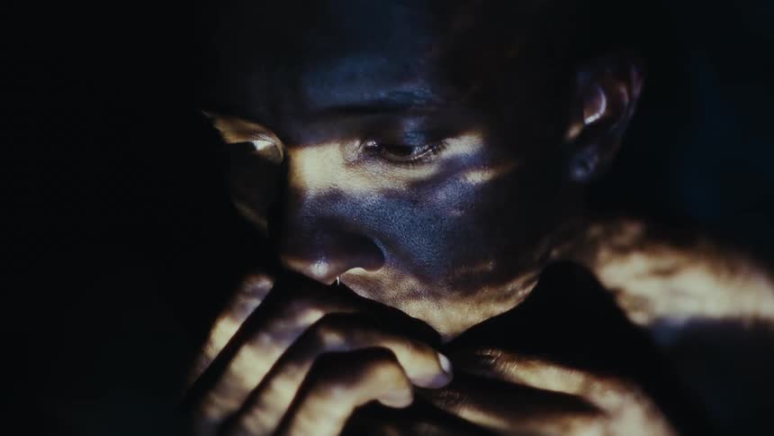 An up close of a persons face looking contemplatively running her hands across her mouth