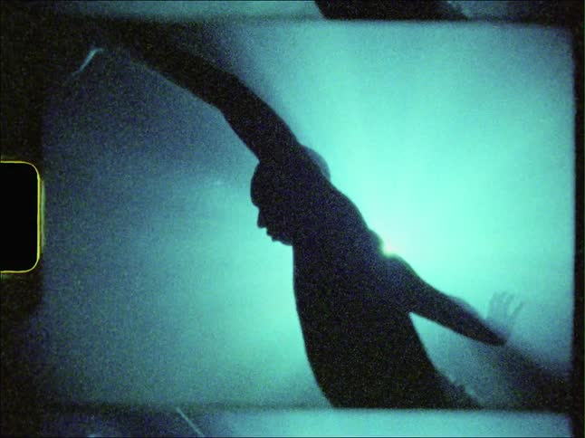 A persons silhouette moving in green light