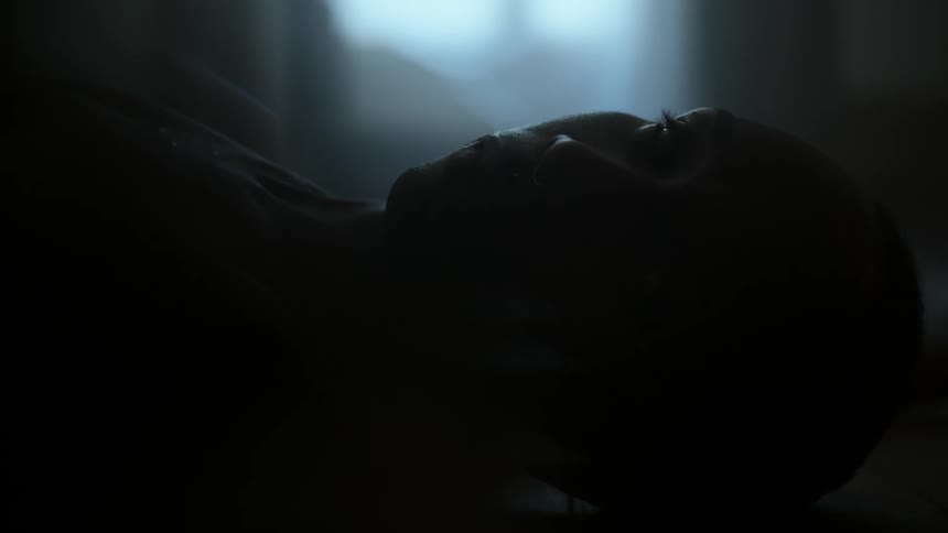A silhouette of a persons face looking up and then left