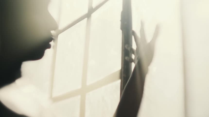 A mans hand stretched on a window with sunlight beaming in
