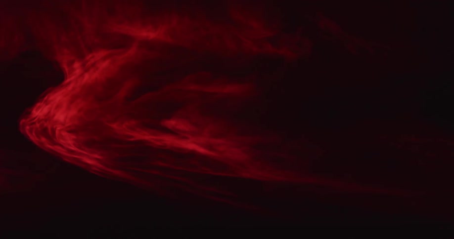 Cloud of dark intense red mist floating against a black background