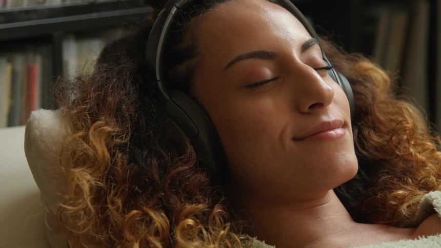 A woman laying around with headphones on