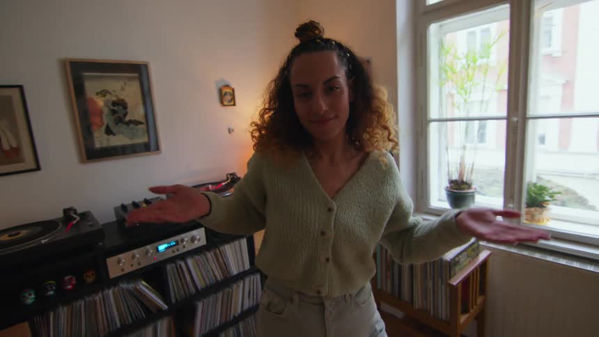 A woman dances around her living room