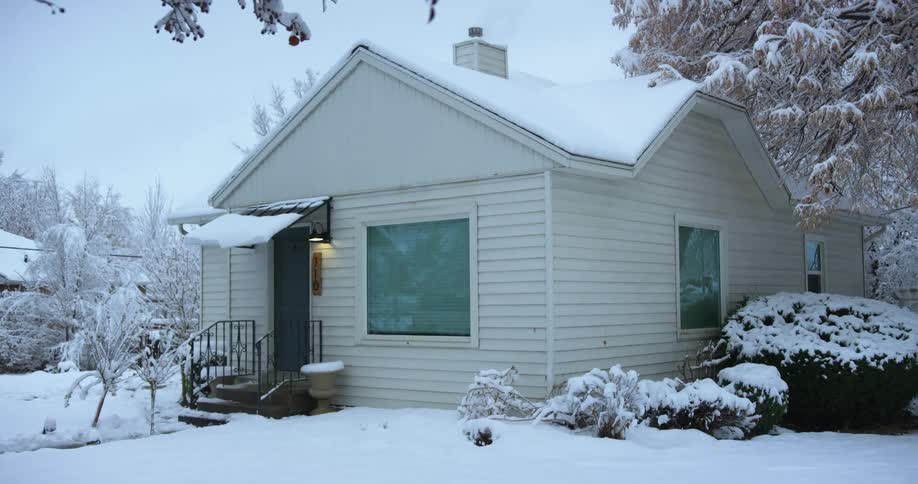 A snow filled landscape with a house and trees