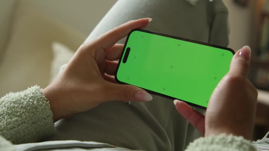 A person is looking at their cell phone indoors