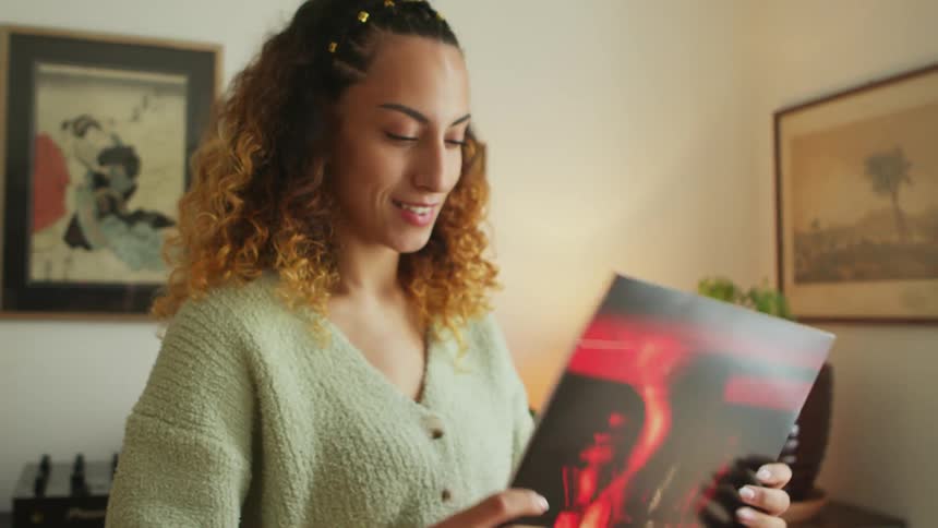 Woman opens a package containing a vinyl record at home