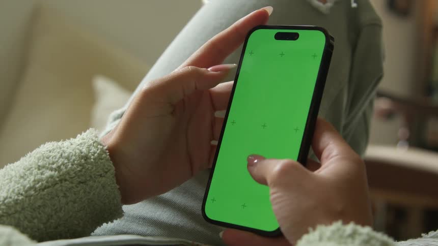 A woman texts on her phone while lying down