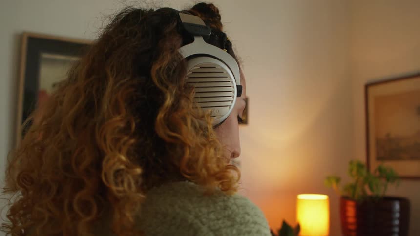 A woman dances while wearing headphones in her living room