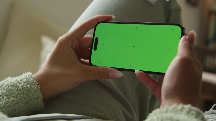 A woman turns her phone to landscape while using it