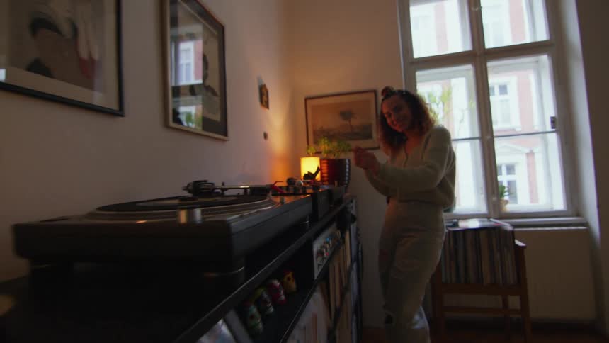 A woman is dancing inside of her house