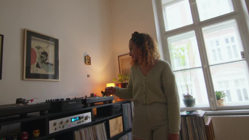 A woman listening to a record player at home