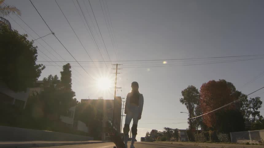Widening shot of a woman revealed to have a skateboard