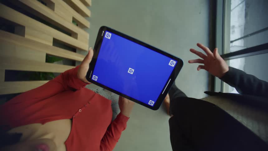 Two people walking in an office with a tablet