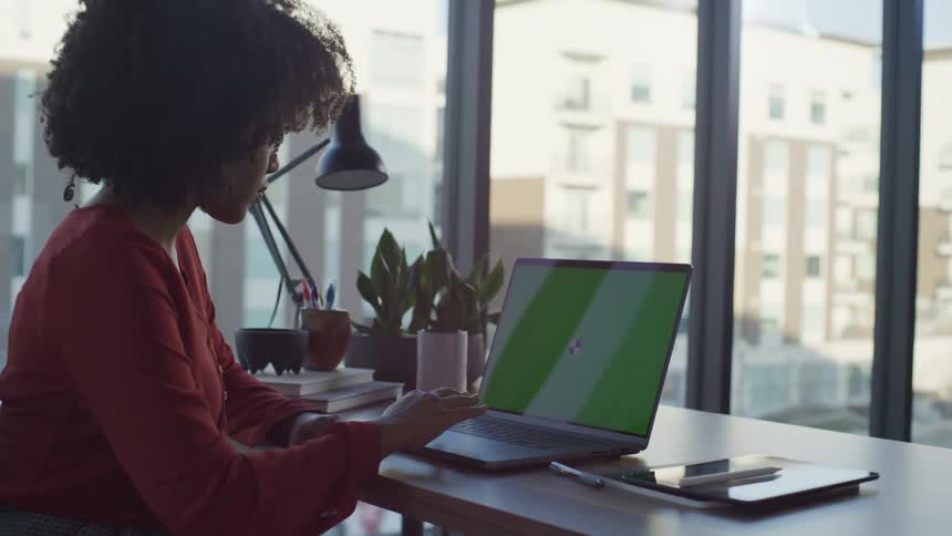 A woman scrolling on a laptop while working in an office