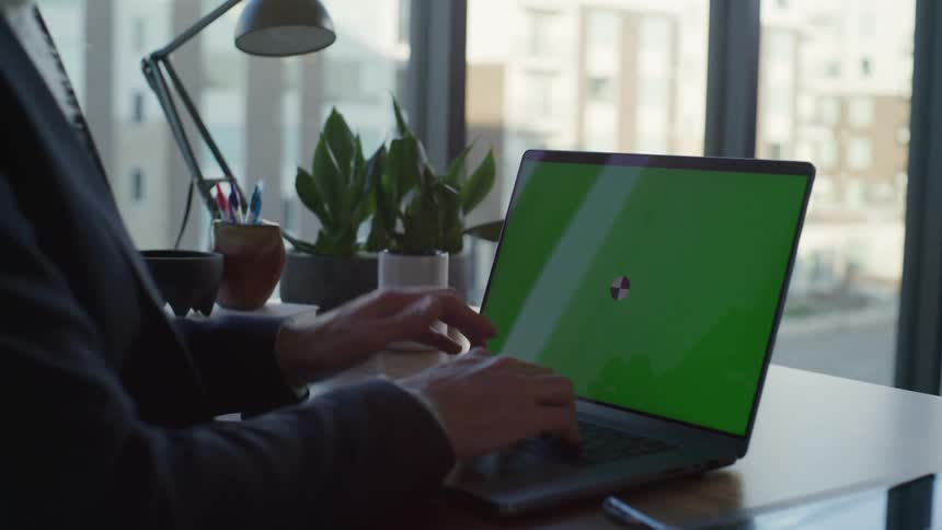 A male employee using a laptop in an office