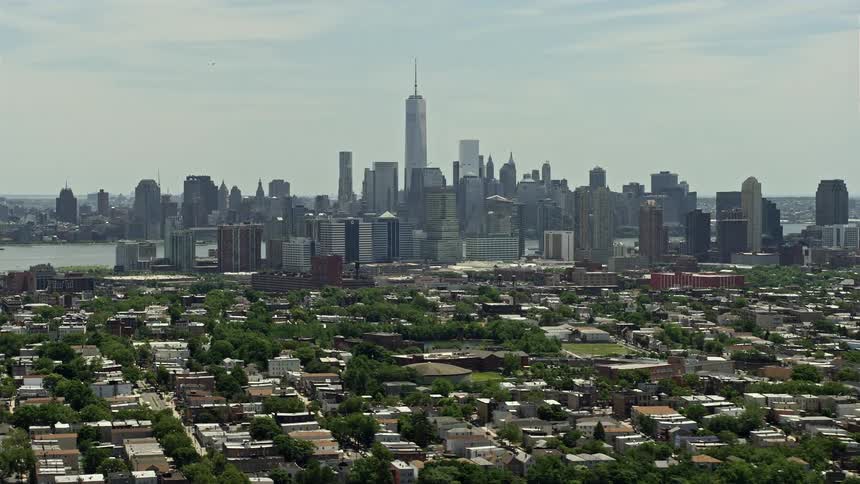 Aerial footage of Lower Manhattan skyline and Downtown Jersey City on a sunny day