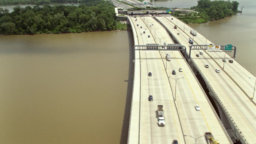 Aerial footage of light traffic on the Woodrow Wilson Memorial Bridge over the Potomac River during a partly cloudy day