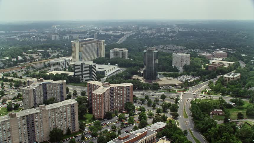 A breathtaking aerial view of apartment complexes office buildings and hotels in Alexandria Virginia during the summer is displayed