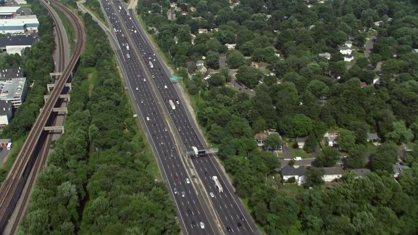 Aerial view of heavy traffic on Interstate 95 tilting up to wider view of Alexandria Virginia during daytime
