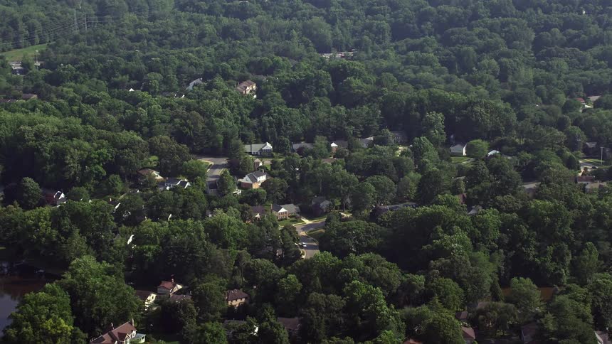 An aerial view of a hazy suburban neighborhood with trees in Annandale Virginia during the spring or summer season