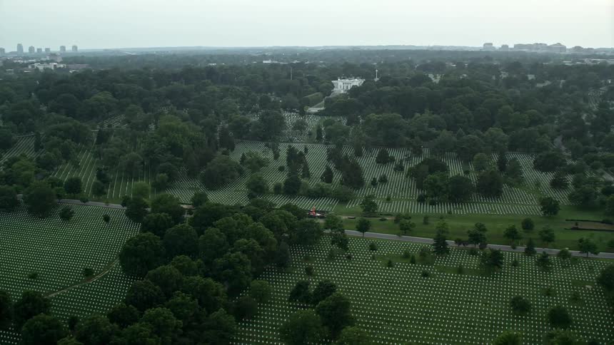 An aerial view at twilight of Arlington National Cemetery featuring gravestones near Arlington House a historic landmark and resting place for armed forces members in Arlington Virginia