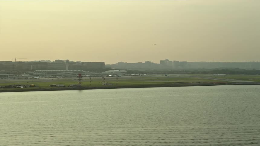 Aerial footage flying by Ronald Reagan Washington National Airport at sunset in Arlington Virginia
