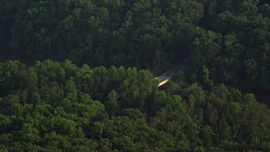 Aerial view of Yates Ford Road bridge partially hidden in the forest during sunset in Clifton Virginia
