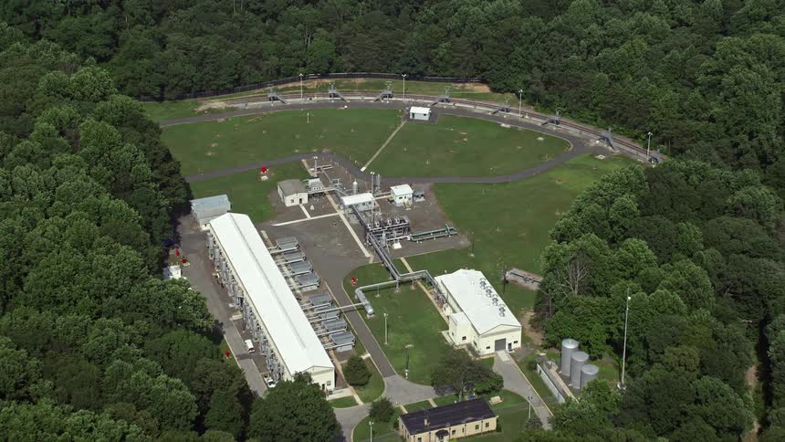 Approaching a sunny day aerial footage captures an industrial area in Springfield Virginia with a tilt down to reveal the manufacturing buildings