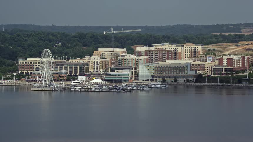 Approaching National Harbor Marina and the Capitol Wheel ferris wheel from an aerial perspective during daytime