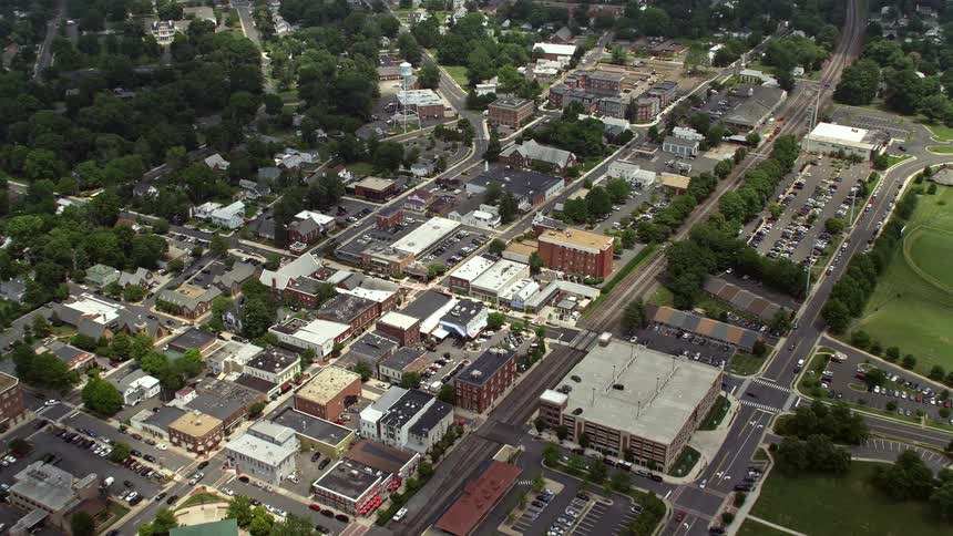 An aerial view of Manassas Virginias city streets shops and water towers on a partly cloudy day