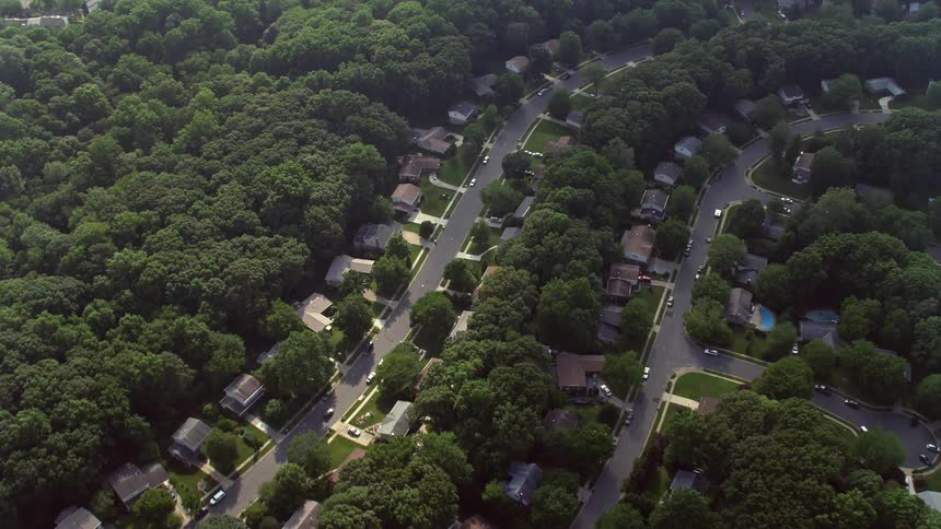 A tilting aerial shot shows rows of suburban homes in Fairfax Virginia viewed from a birds-eye perspective during daytime