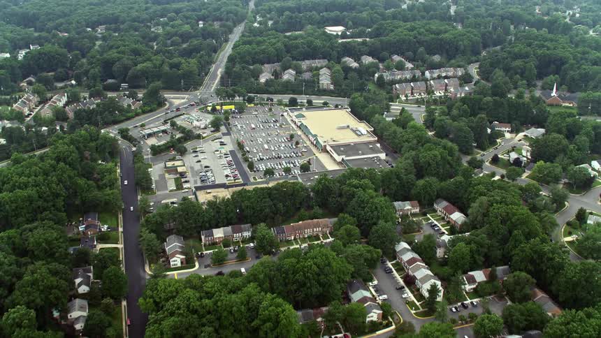 Aerial footage over a suburban area and highways approach towards Burke Town Plaza Virginia during daytime