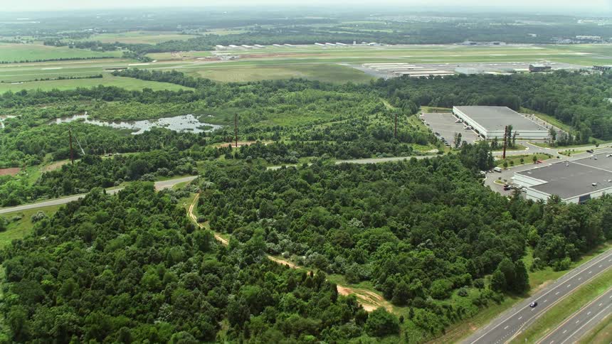 Flying over Prince William Parkway intersection towards Manassas Regional Airport in Virginia with highway and countryside roads visible