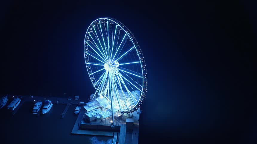 Aerial footage captures the glittering Capitol Wheel and National Harbor Marina at night in Maryland