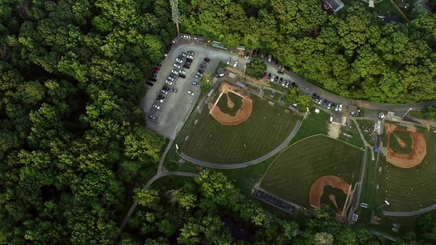 A stunning aerial view of high school baseball fields and a neighboring community bathed in a warm sunset glow in Springfield Virginia