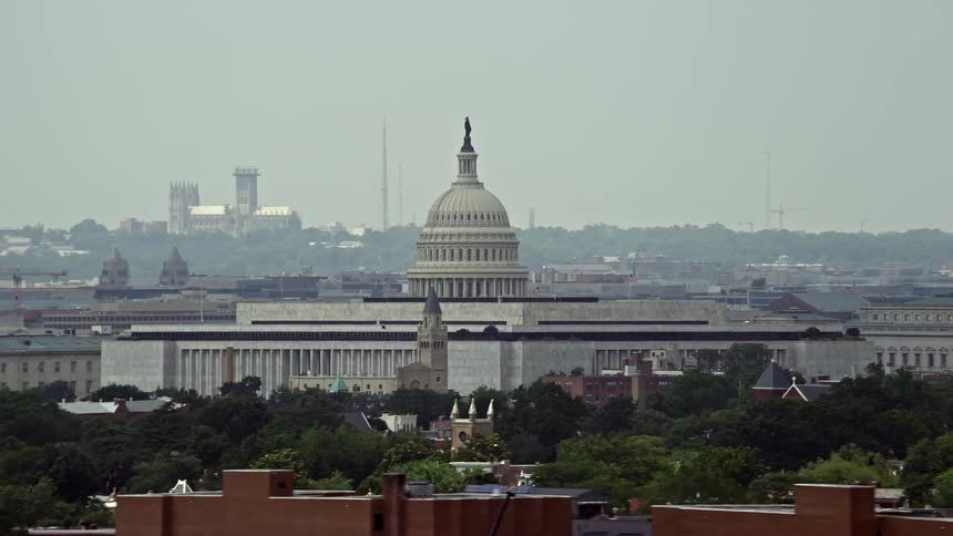 Aerial footage of the United States Capitol Building and Dome on a hazy day in Washington DC