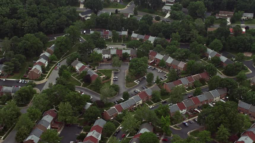 An aerial view of a Virginia suburban area showing row houses tree-lined streets and cloudy skies