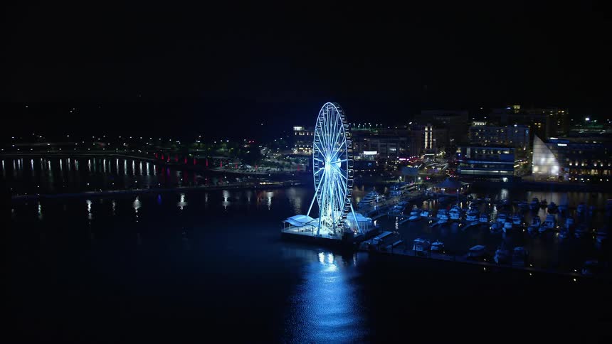 An aerial view of the Capitol Wheel and marina with Gaylord National Resort & Convention Center unveiling in the night sky at National Harbor Maryland