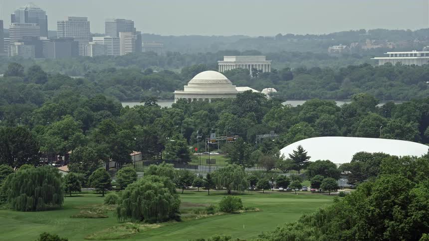 Aerial footage of the iconic Jefferson Memorial and nearby trees in West Potomac Park during a hazy day in Washington DC