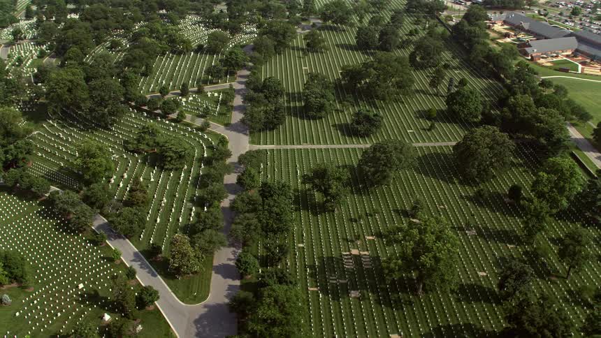 An aerial view of Arlington National Cemetery a famous and historic landmark in Washington DC displaying rows of gravestones with bright and sunny weather conditions