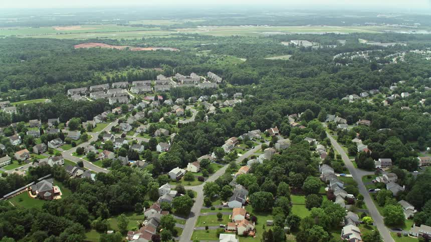 The aerial footage captures the approach to Prince William County Fairgrounds flying over ponds and suburban homes in Manassas Virginia during a hazy summer day
