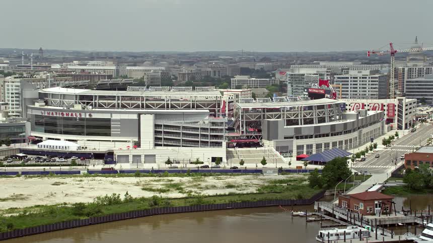 Aerial footage of Nationals Park a baseball stadium in Washington DC seen from the river with a bridge in the foreground