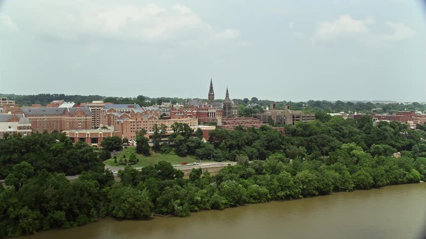 Aerial view of Georgetown University campus and buildings on waterfront seen from Potomac River in cloudy weather