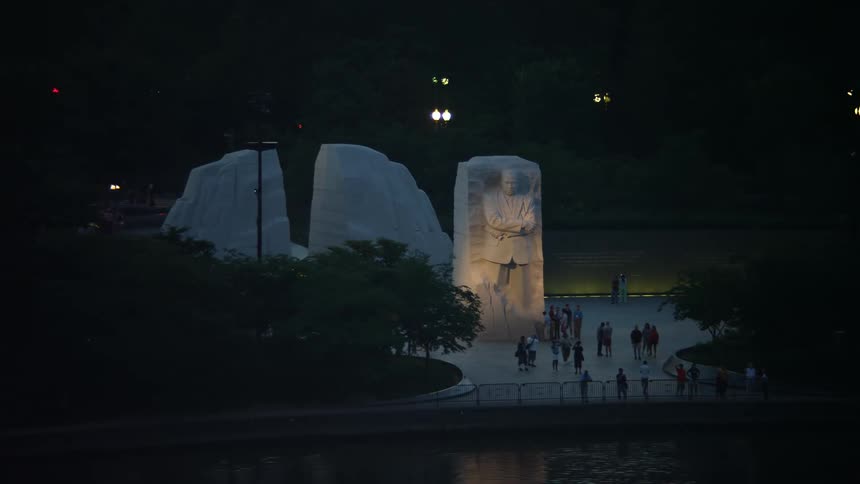 Aerial footage of Martin Luther King Jr National Memorial lit up at night during twilight in Washington DC
